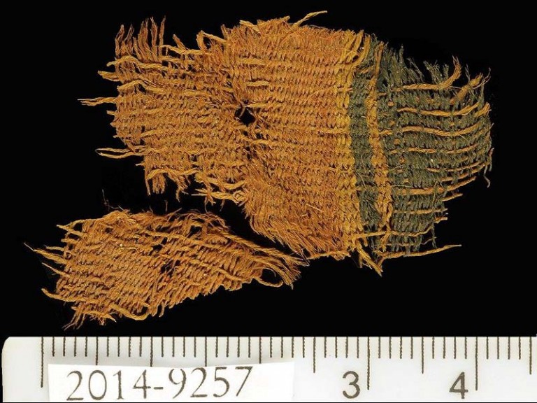 Fine wool textile dyed red and blue. The textile used the varying colors of natural animal hair to create black and orange-brown colors for decorative bands. (Photo: Clara Amit, courtesy of the Israel Antiquities Authority/JNi Media)